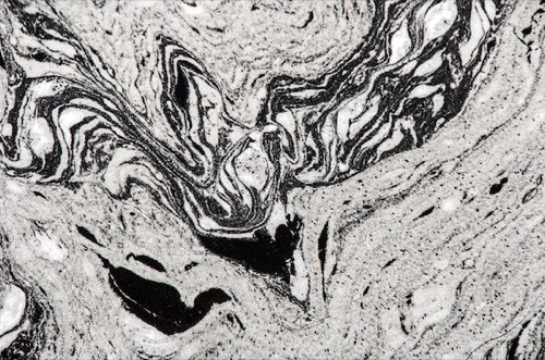 Swirling foam in moving water takes on the shape of birds.